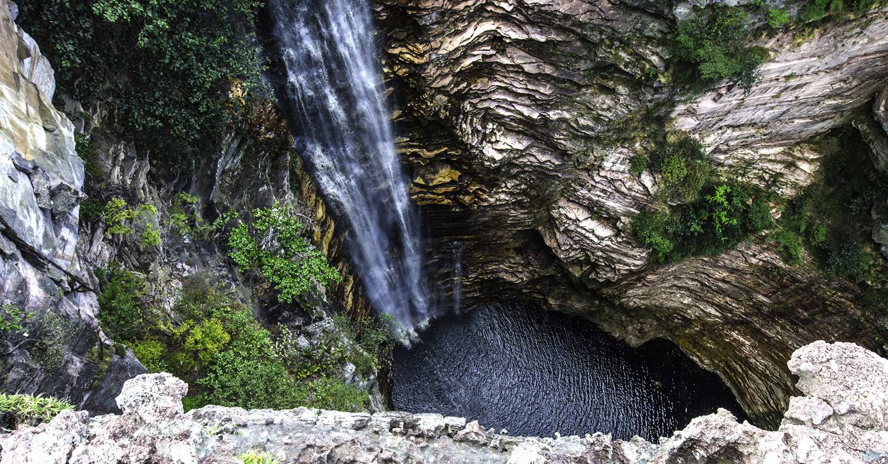 Cachoeira caindo dentro de uma gruta de pedra, exemplo da diversidade natural brasileira